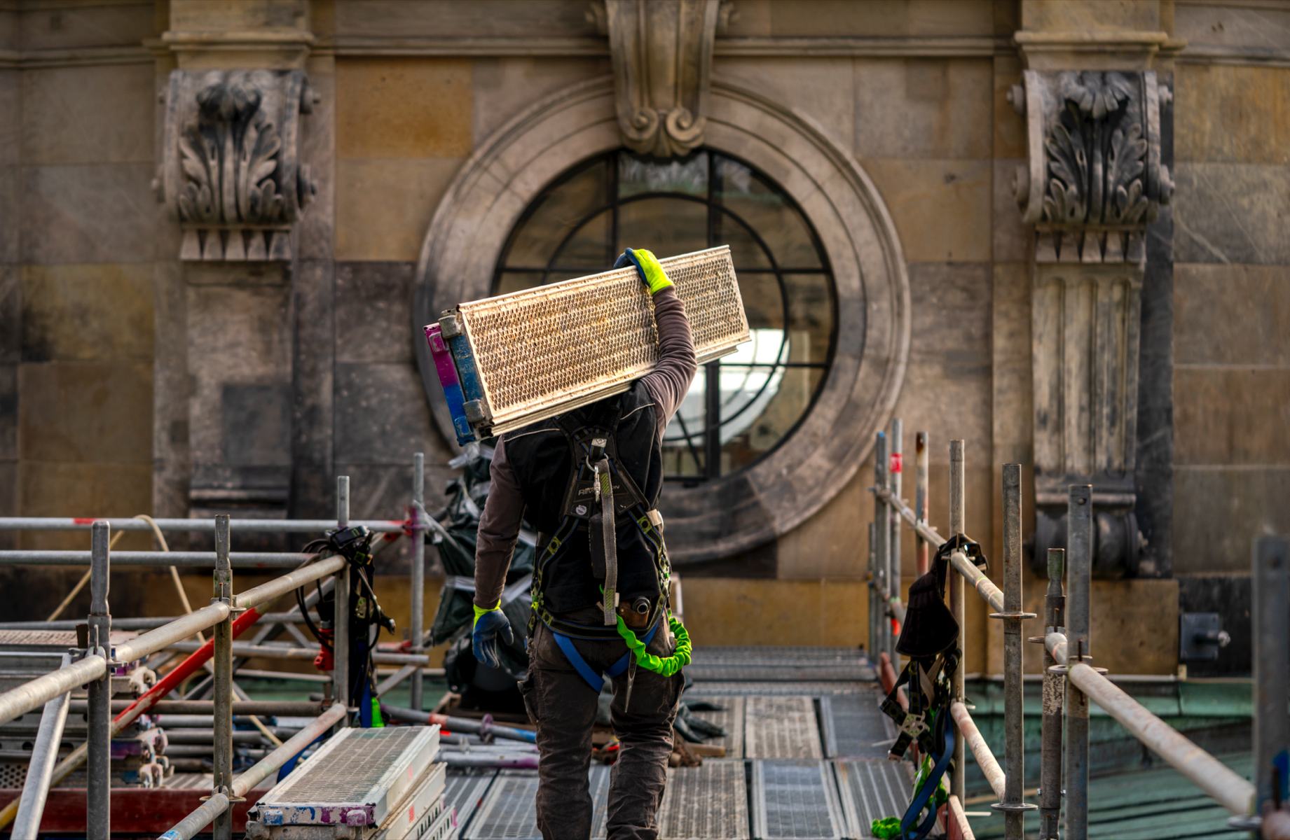 Gerüstbauer trägt Material am Berliner Dom